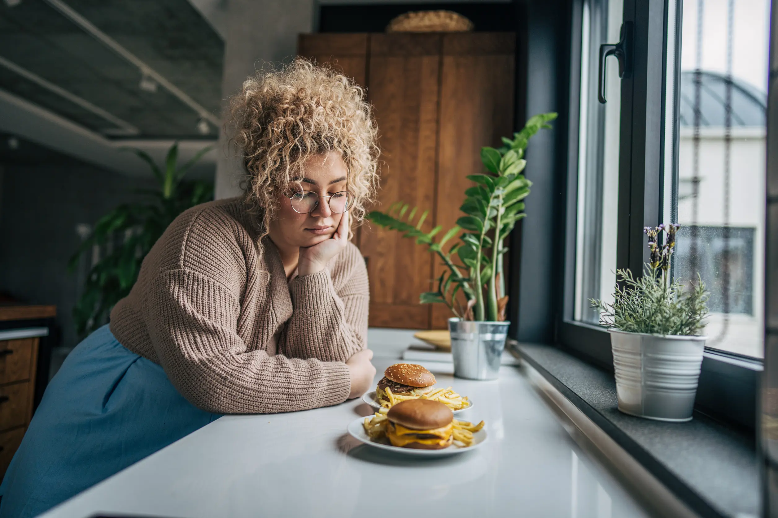 Mulher pensativa diante de alimentos